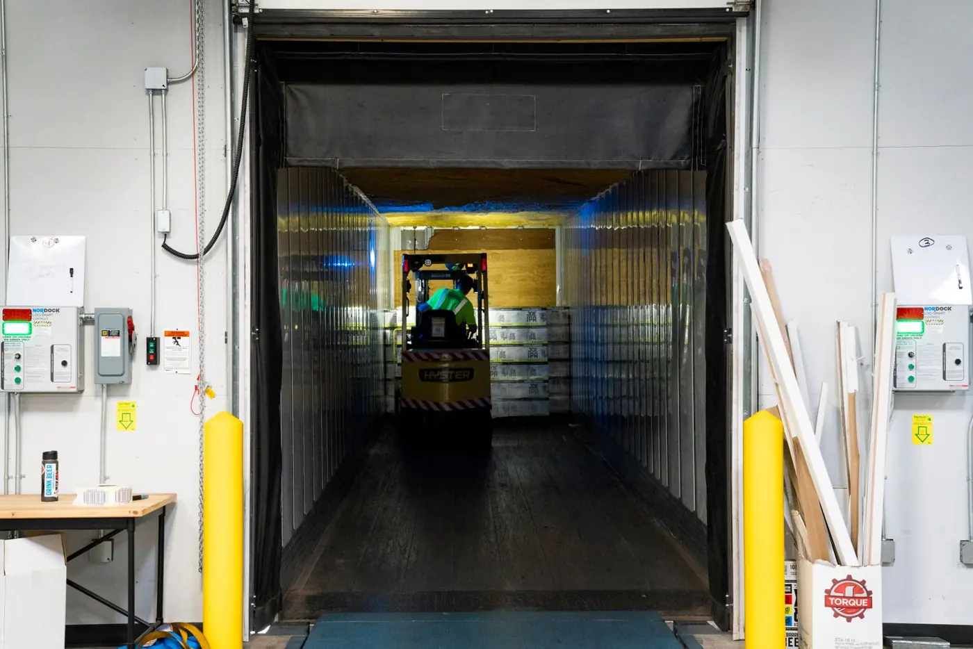 Forklift working inside an open loading dock at a warehouse